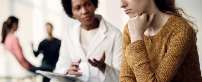 mujer-triste-joven-que-tiene-reunion-psicoterapeuta-centro-medico